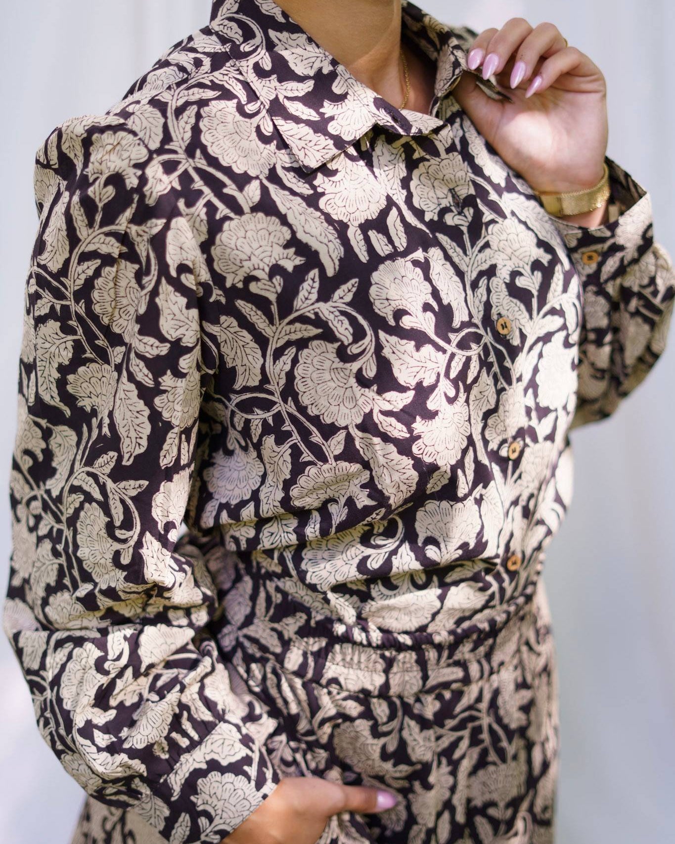 Person wearing a patterned outfit with a neutral background
