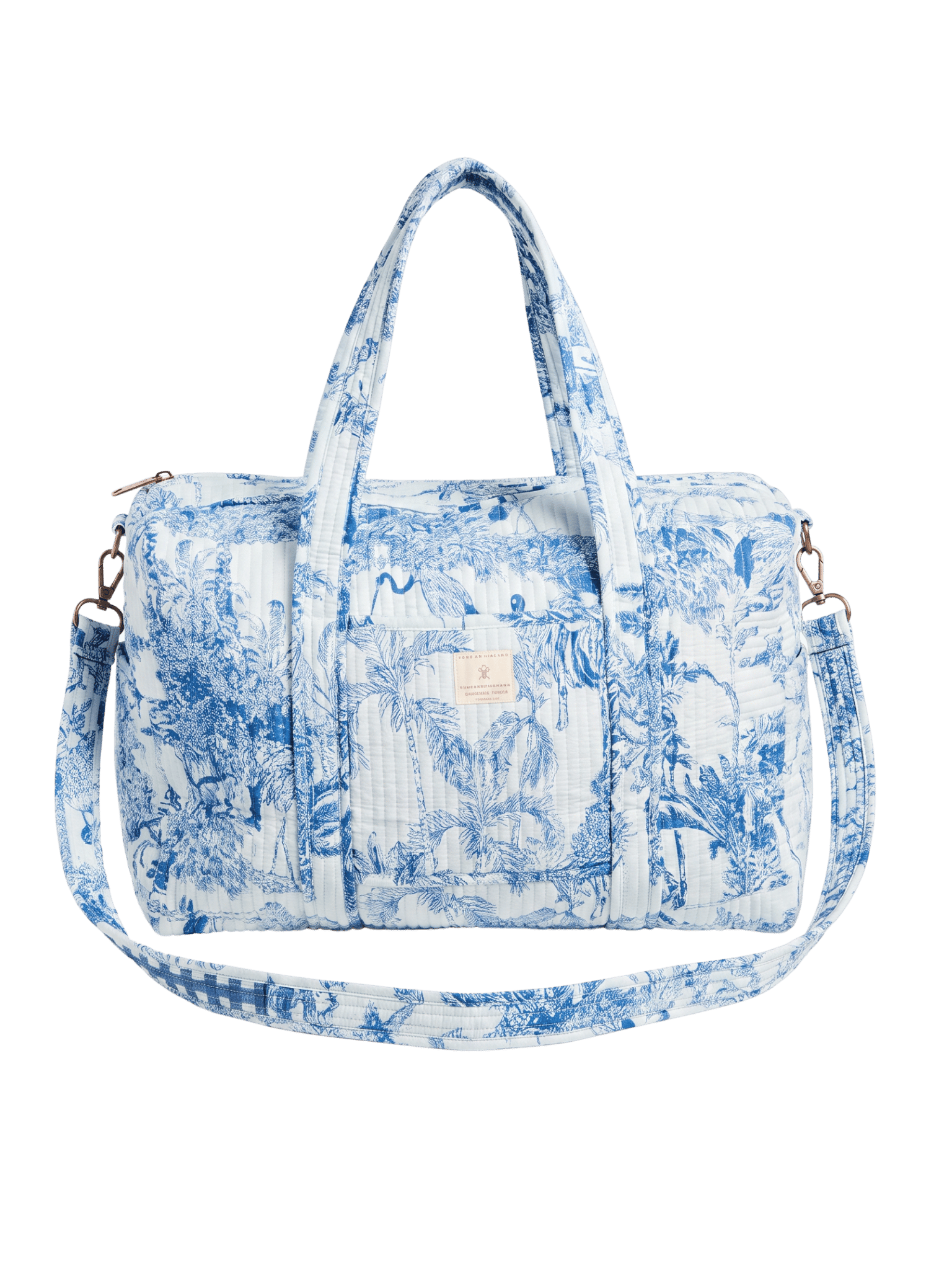 Quilted duffel bag in blue and white toile print with jungle animals and palm trees, dual top handles, adjustable blue gingham crossbody strap, and gold-tone hardware, shown against a plain background