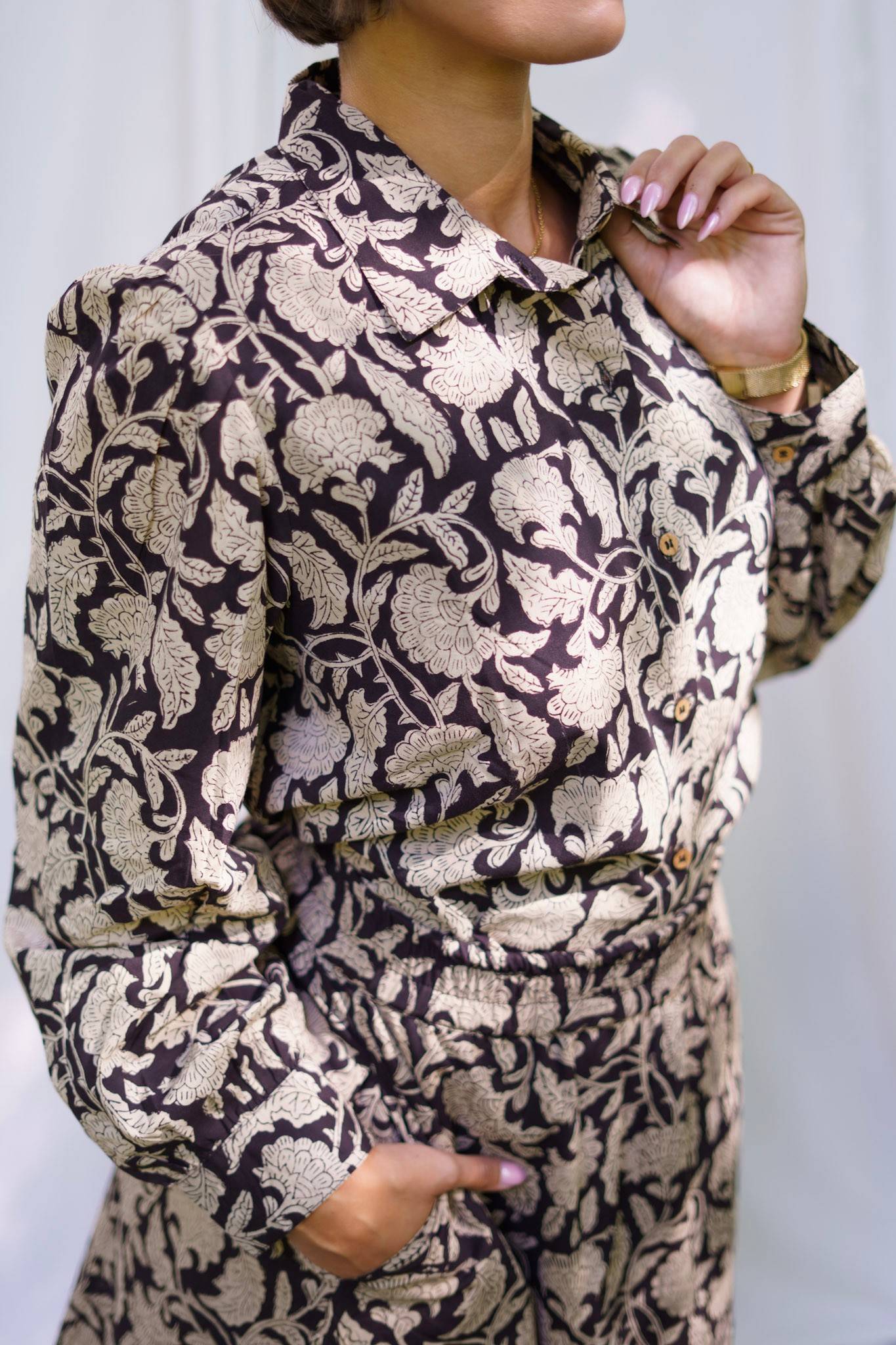Person wearing a patterned outfit with a neutral background
