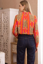 Back view of the Tibetan Tiger Blouse showing the yoke, box pleat, and tiger-stripe print continuing across the back and sleeves